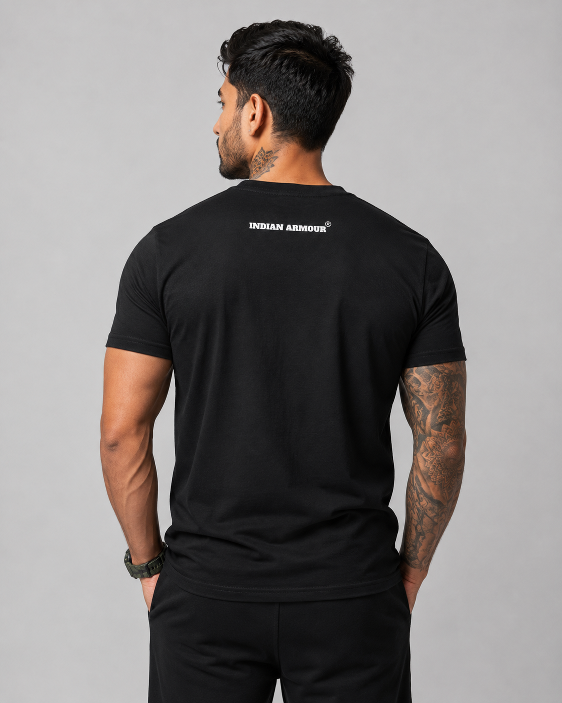 A man viewed from the back wearing a black short-sleeve t-shirt with 'INDIAN ARMOUR' printed in white on the upper back